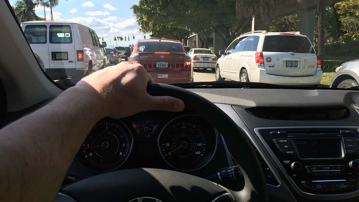 Driver's perspective of Miami traffic on a busy highway.