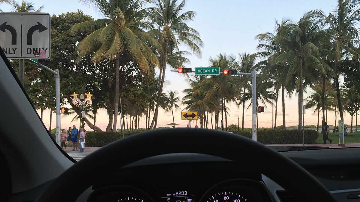 Driving on Ocean Drive in Miami Beach, a high-risk area for rental car accidents.