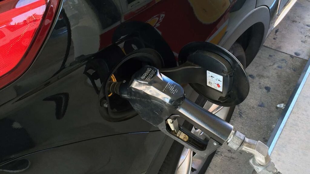 Pumping gas at a Shell station in Miami, a common ritual for car-dependent travelers.