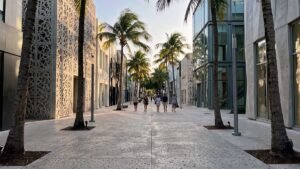 Street-level view of unique architecture and palm trees in Paseo Ponti, Miami Design District, showing the authentic, slow travel vibe.