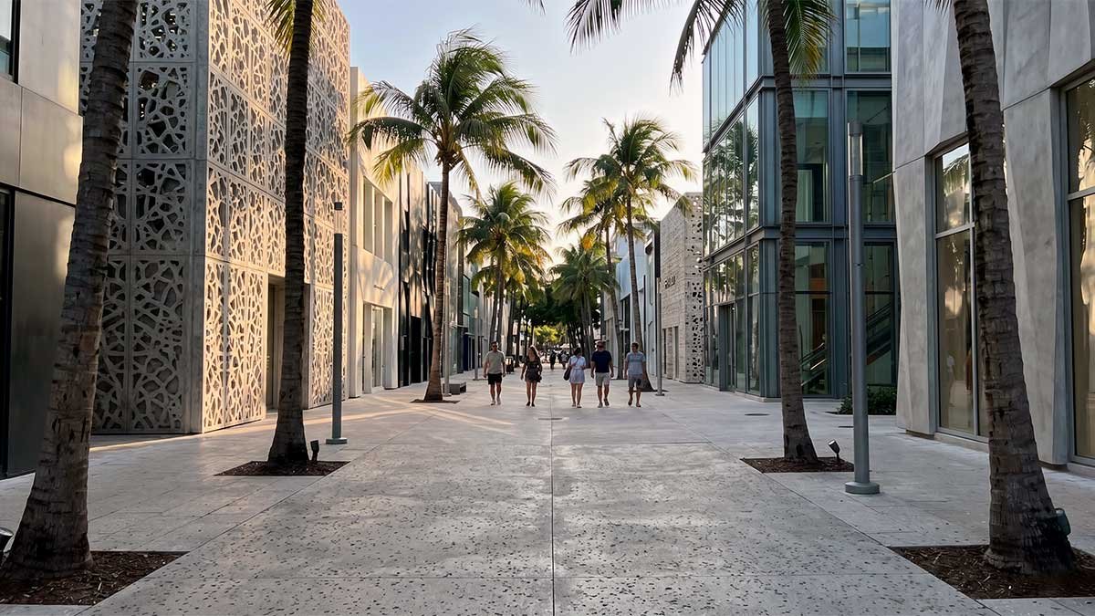Street-level view of unique architecture and palm trees in Paseo Ponti, Miami Design District, showing the authentic, slow travel vibe.