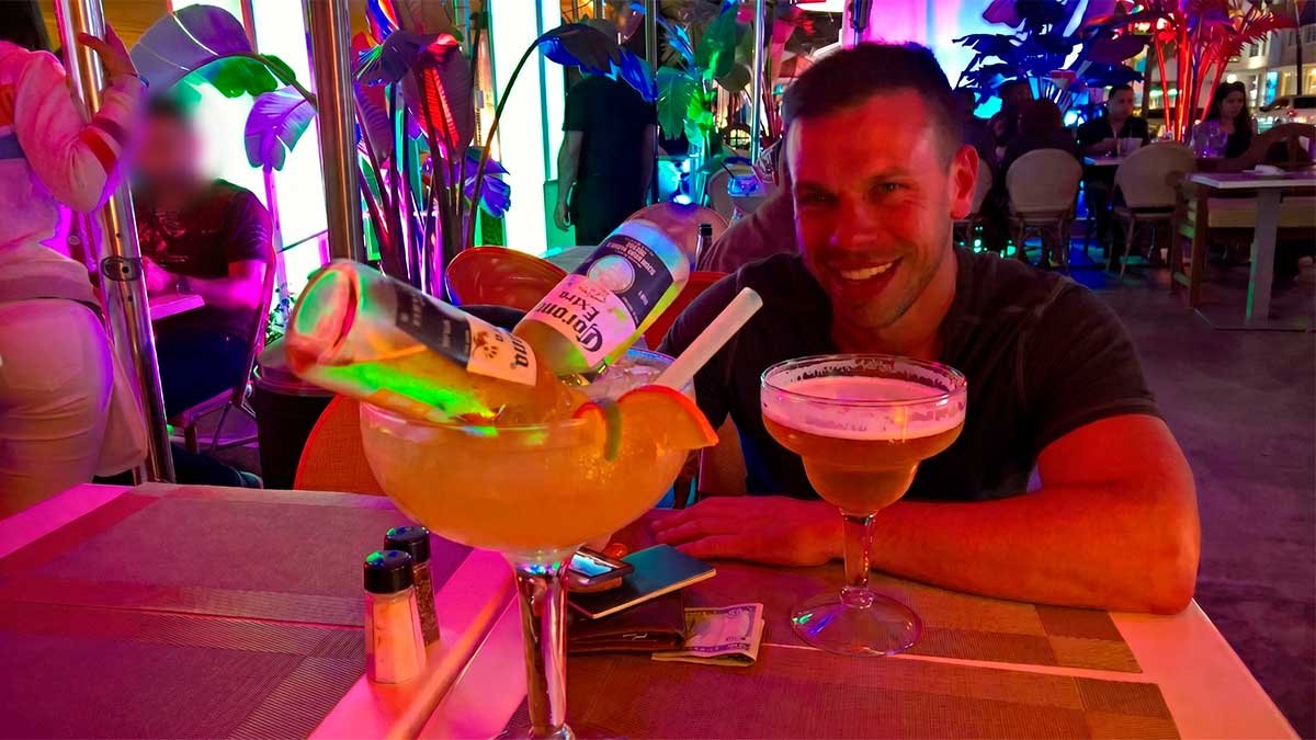 A cautionary example of dining on Ocean Drive, South Beach, illustrating how giant drinks often lead to the 20% automatic Miami service charge scandal.